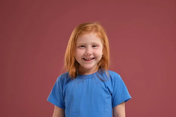 Aranyos vörös hajú portréja érzelmi kislány, piros háttér — Stock Fotó