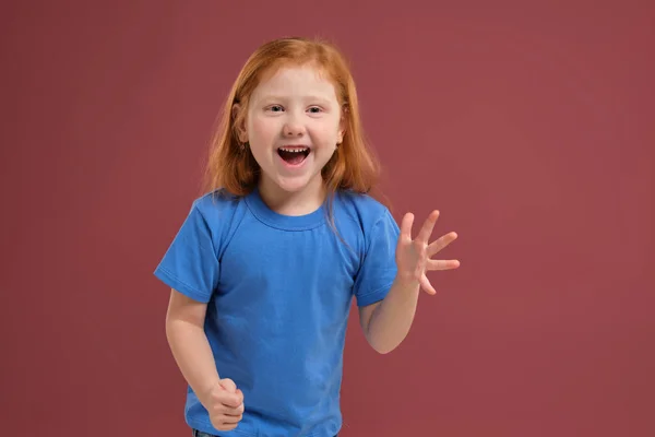 Aranyos vörös hajú portréja érzelmi kislány, piros háttér — Stock Fotó