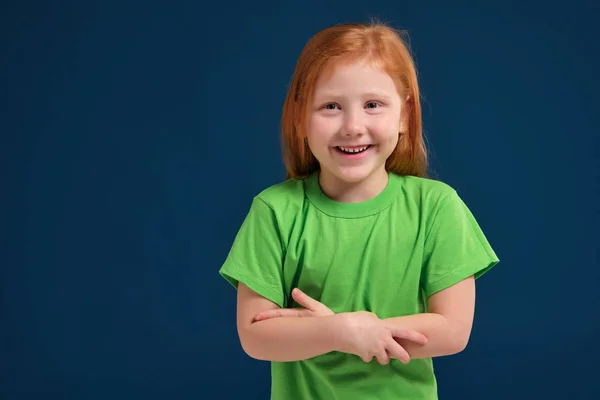 青の背景にカメラの前にポーズをとって少し赤毛の感情的な女の子の写真をクローズ アップ — ストック写真