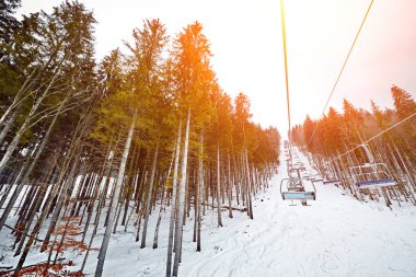 Ski lift, Kayak Merkezi Bukovel bir güneşli kış gününde dağlarda. Güneş parlaması