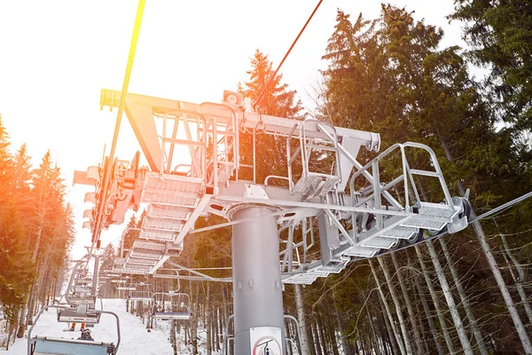 Ski lift at ski resort Bukovel in the mountains on a sunny winter day. Sun flare — Stock Photo, Image