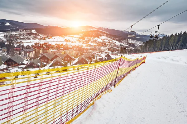 Panorama de estância de esqui, declive, pessoas no teleférico, esquiadores na pista entre pinheiros verdes e lanças de neve . — Fotografia de Stock
