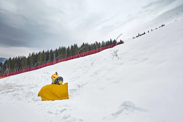 Panorama von Skigebiet, Piste, Menschen am Skilift, Skifahrer auf der Piste zwischen grünen Kiefern und Schneelanzen. — Stockfoto