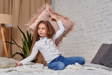 Sevimli duygusal küçük kız yatakta yastık ile portresi