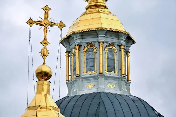 Eastern orthodox crosses on gold domes, cupolas, against blue sky with clouds