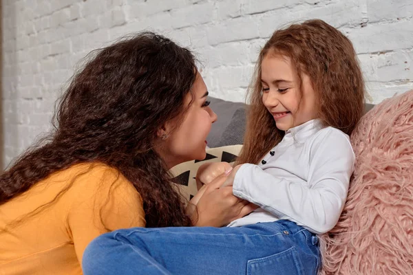 Liebe zu junger Mutter und Tochter. sie liegen zu Hause auf dem Bett und haben Spaß — Stockfoto