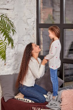 Anne ve kızı Oda penceresinde yakınındaki eşiğinde oturuyor