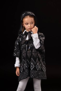 Küçük kız bir başlık ve karanlık bir panço