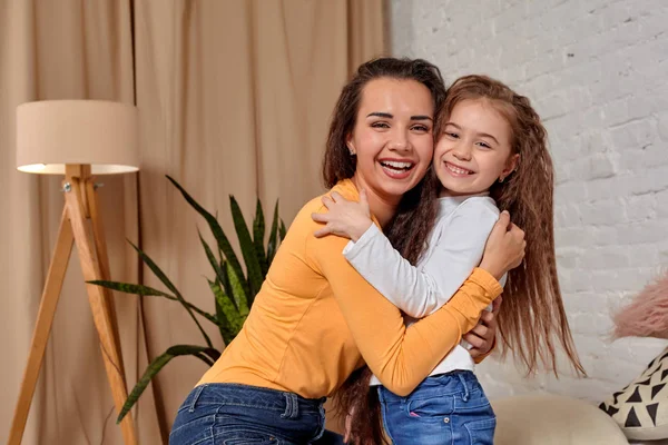 Liebe zu junger Mutter und Tochter. Sie sitzen zu Hause auf dem Bett und haben Spaß — Stockfoto