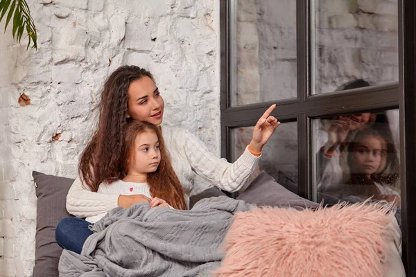 Mãe e filha sentadas no peitoril perto da janela no quarto — Fotografia de Stock