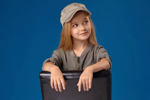 Sapkát, egy széken ülve szürke szeme és szőke kis lány — Stock Fotó