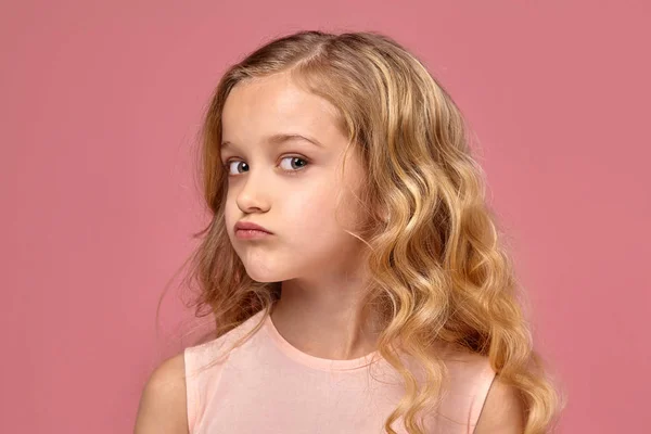 小女孩与金发卷发, 在粉红色的礼服是摆姿势的相机 — 图库照片