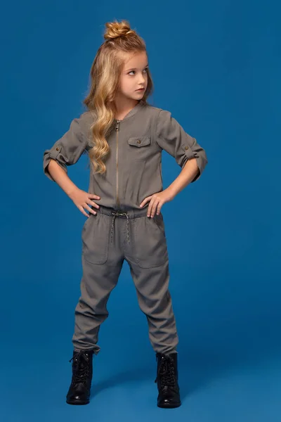 Маленькая девочка в модной одежде на синем фоне — стоковое фото