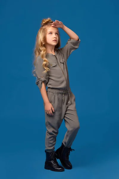 Kis lány a divatos ruhák a kék háttér — Stock Fotó