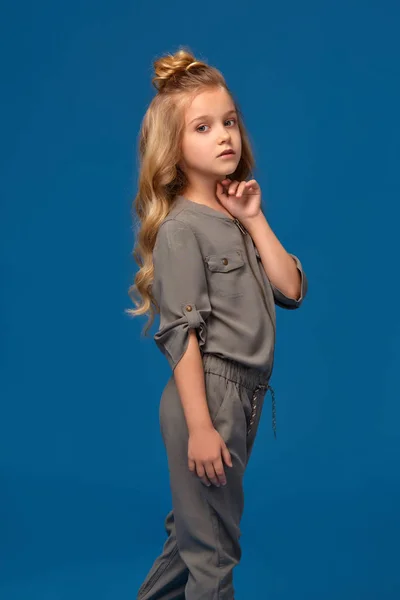 Menina em uma roupa na moda no fundo azul — Fotografia de Stock