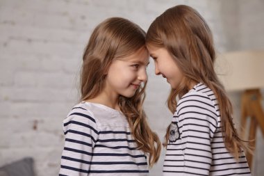 İki küçük kız yatak odasında oturup resim.