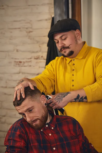 Friseur schneidet attraktiven bärtigen Mann im Friseursalon — Stockfoto