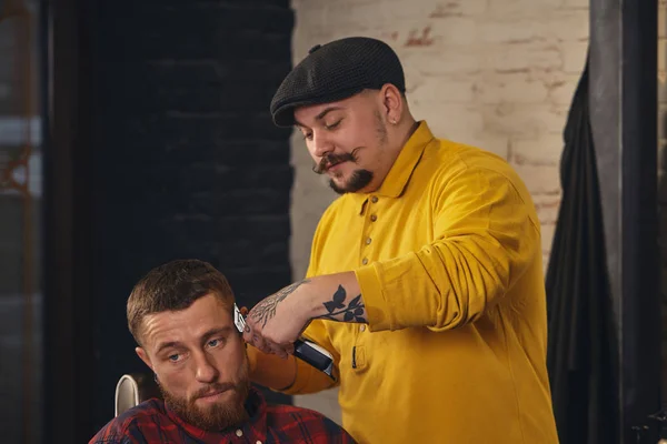 Friseur schneidet attraktiven bärtigen Mann im Friseursalon — Stockfoto