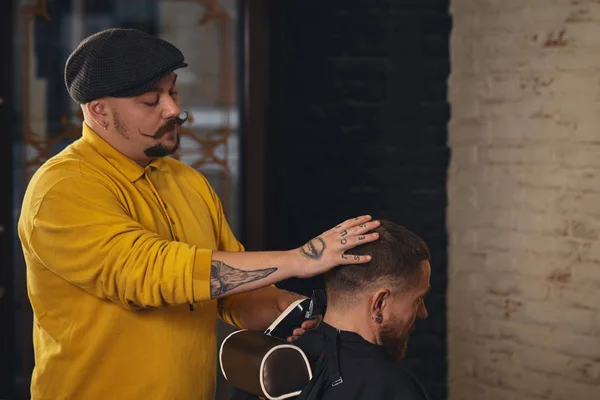 Friseur schneidet attraktiven bärtigen Mann im Friseursalon — Stockfoto
