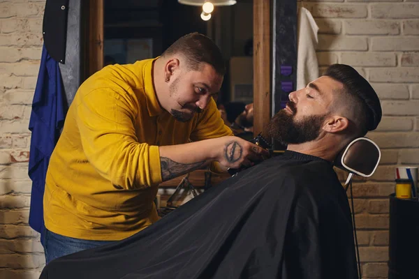 Kundin mit dickem schwarzen Bart beim Bartrasieren im Friseurladen — Stockfoto