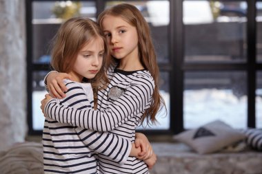 İki küçük kız yatak odasında oturup resim.