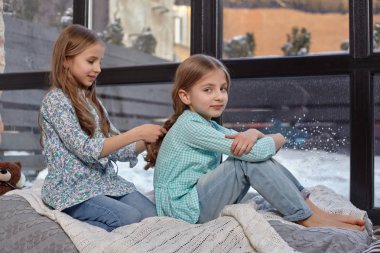 Pencere huzur içinde oturan iki sevimli küçük kız resim