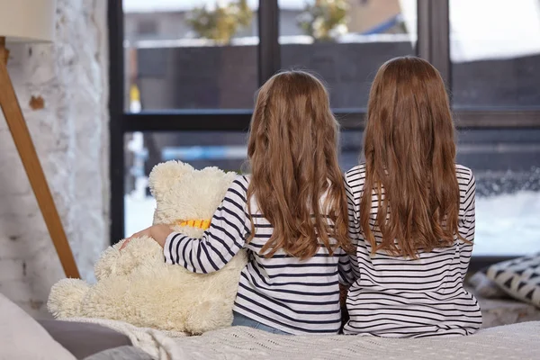 L'image de deux petites sœurs assises sur le lit dans la chambre . — Photo