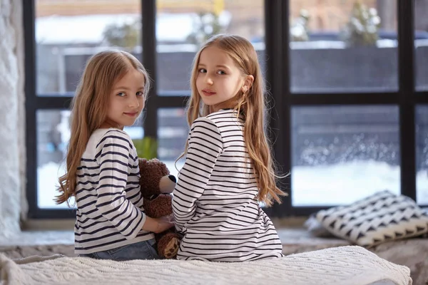 Obrázek dvou sestřičky sedí na posteli v pokoji. — Stock fotografie