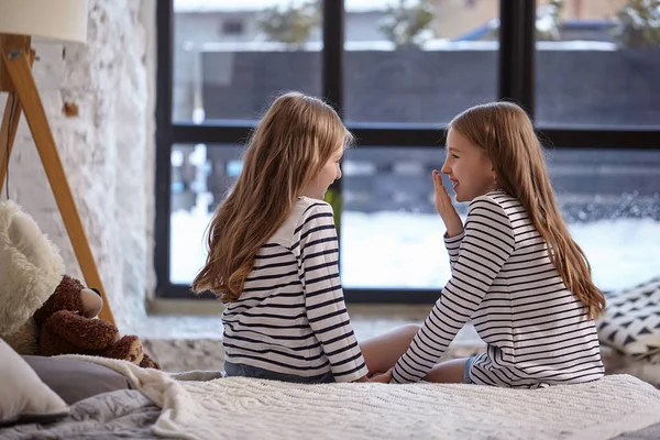 L'image de deux petites sœurs assises sur le lit dans la chambre . — Photo