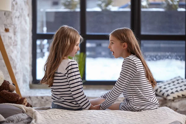 L'image de deux petites sœurs assises sur le lit dans la chambre . — Photo