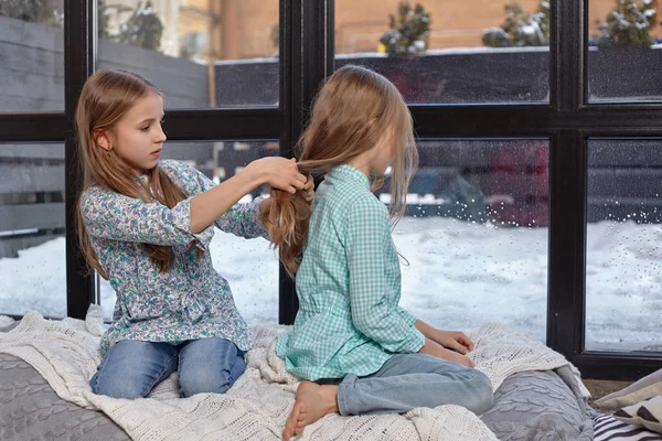 L'image de deux jolies petites sœurs assises sur le rebord de la fenêtre dans la paix et la tranquillité — Photo