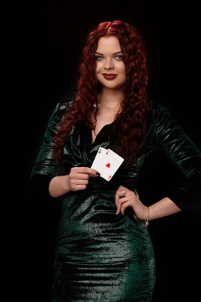 Seksowna Rudowłosa kobieta stwarzających z karty do gry w jej ręce, na czarnym tle — Zdjęcie stockowe