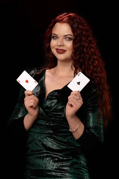 Sexy rossa donna in posa con un gioco di carte nelle sue mani, su sfondo nero — Foto Stock