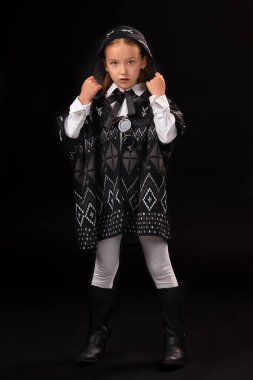 Küçük kız bir başlık ve karanlık bir panço