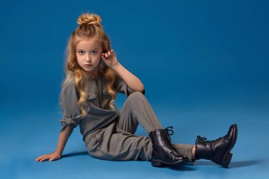 Moda giysiler içinde uzun kıvırcık saçlı küçük kız