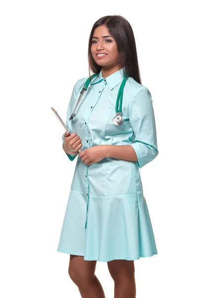 Чарівна індійська жінка-лікар медсестра зі стетоскопом в аквамаринній сукні ізольована на білому тлі — стокове фото