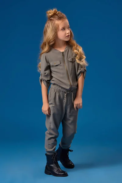 Маленькая девочка с длинными вьющимися волосами в модной одежде — стоковое фото