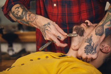 Berber dükkanında sakal tıraşı olan bir müşteri.