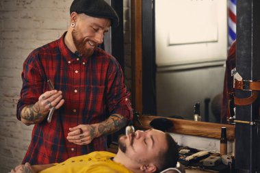 Berber dükkanında sakal tıraşı olan bir müşteri.