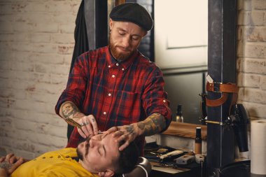 Berber dükkanında sakal tıraşı olan bir müşteri.