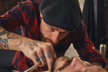 Berber dükkanında sakal tıraşı olan bir müşteri.