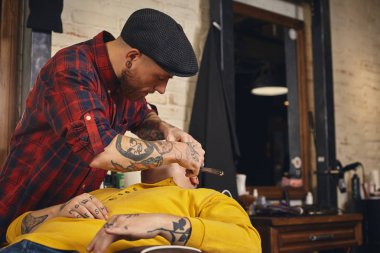 Berber dükkanında sakal tıraşı olan bir müşteri.