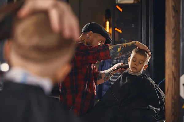Caucasiano menino recebendo corte de cabelo na barbearia interior — Fotografia de Stock