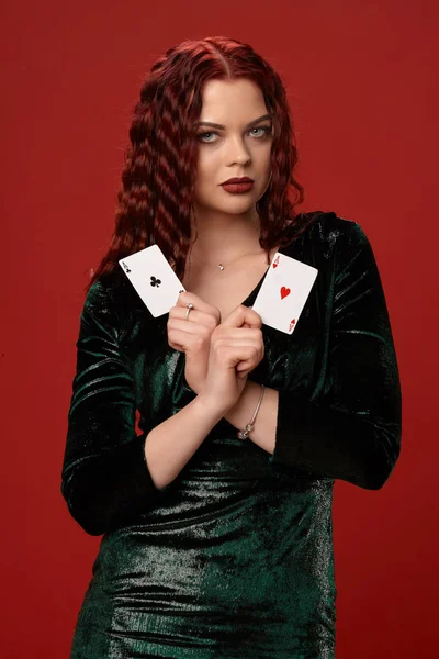 エース、赤い背景の上に保持している赤い巻き毛を持つ若いセクシーな女性。火かき棒 — ストック写真