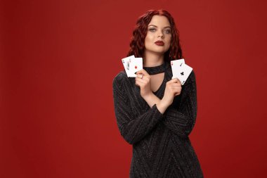 Güzel kızıl saçlı kadın bazı iskambil tutuyor. Casino