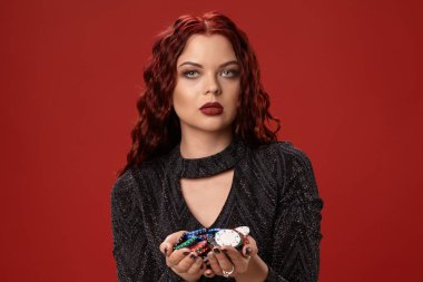 Güzel kızıl saçlı kadın kumar cips tutuyor. Casino