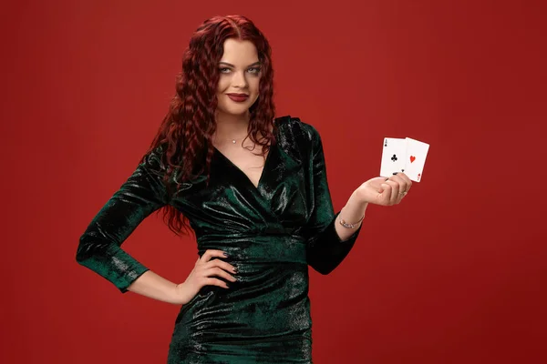 Fiatal szexi nő, egy vörös göndör haja gazdaság ász, piros háttéren. Póker — Stock Fotó