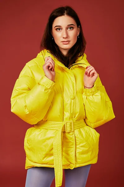 Retrato de estudio de una joven morena con chaqueta amarilla y pantalón azul gris mangueras o medias. Captura de estudio — Foto de Stock