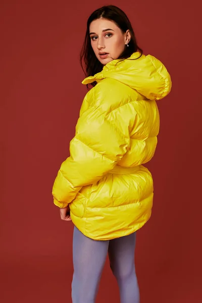 Retrato de estudio de una joven morena con chaqueta amarilla y pantalón azul gris mangueras o medias. Captura de estudio — Foto de Stock