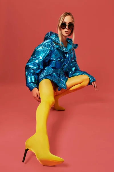 Kendine güvenen genç sarışın kız mavi ceketli Studio kamera, kırmızı arka plan önce ağız kavgası — Stok fotoğraf